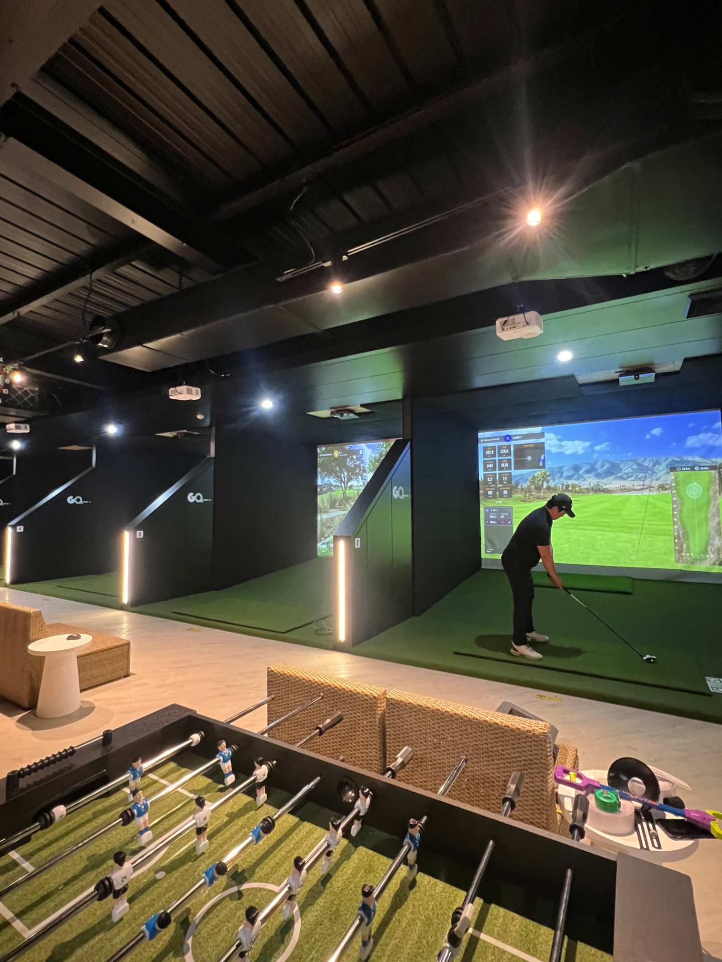 A golfer playing a virtual course in a TrackMan bay at Golf Q Meadowbank